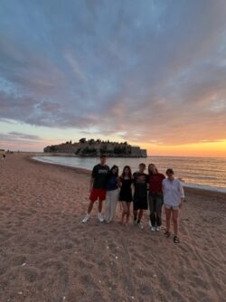 a group of people on a beach at sunset